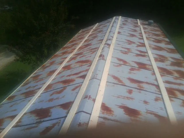 Rusted metal roof panels with new wood purlins before replacement — Storm Damage Roof Repair in Newell by Roofing Brothers